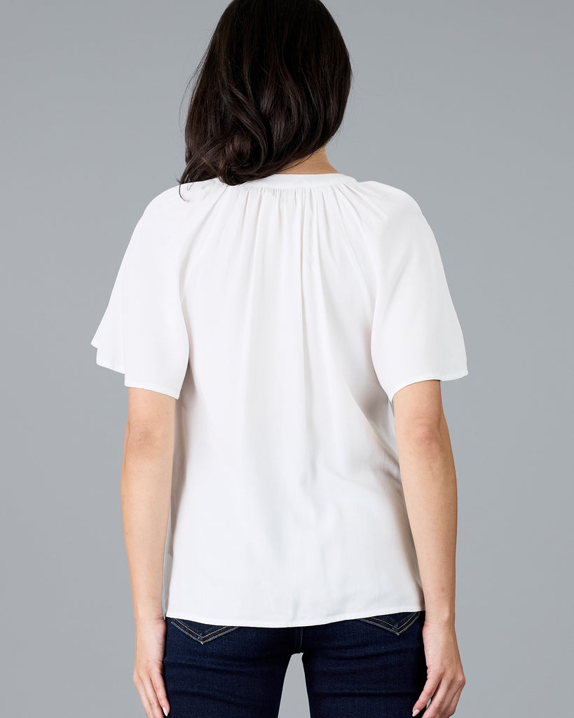 Woman in a short sleeve v-neck white blouse