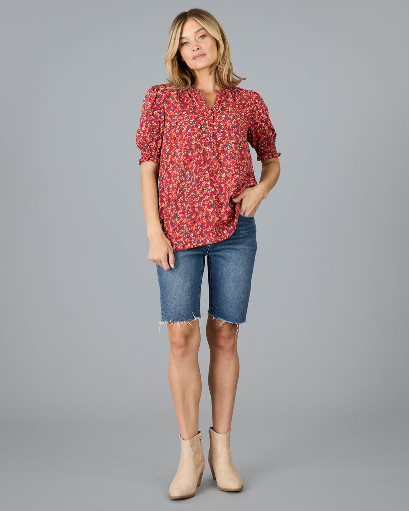 Woman in a red floral print short sleeve blouse