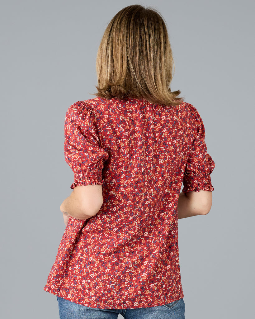 Woman in a red floral print short sleeve blouse