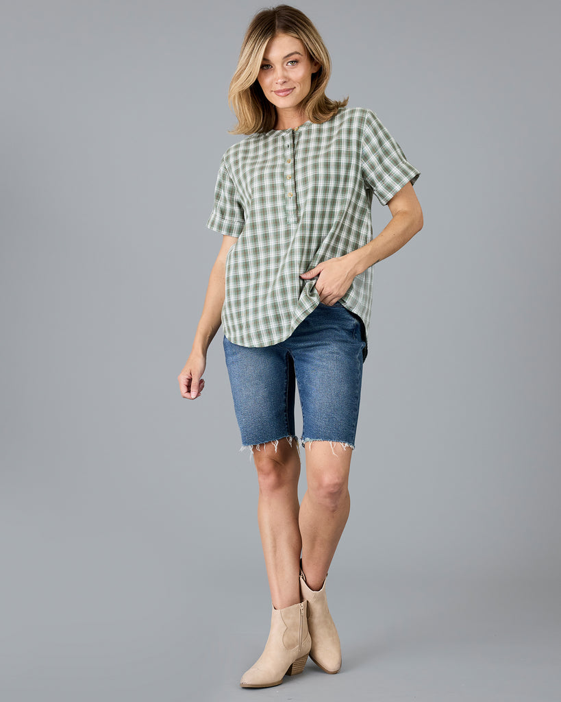 Woman in a plaid green short sleeve blouse