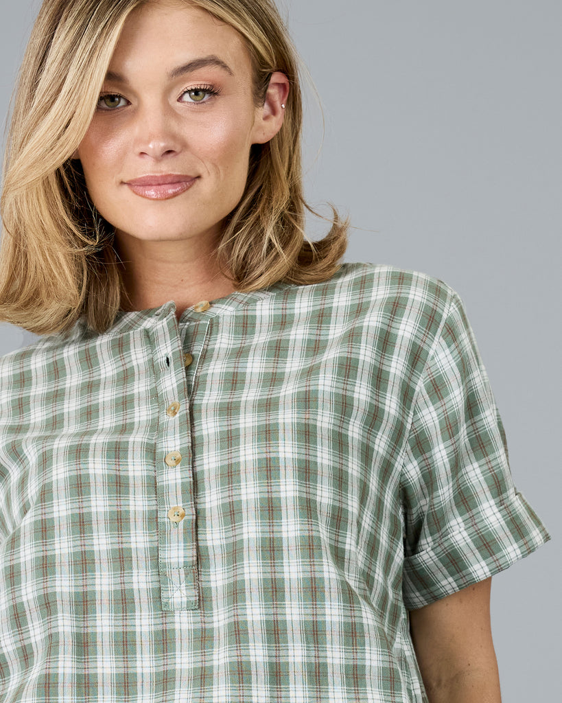 Woman in a plaid green short sleeve blouse