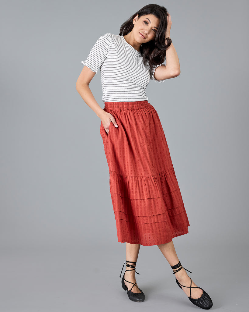 Woman in a midi length orange skirt