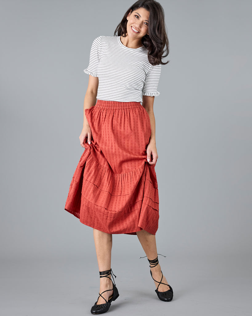 Woman in a midi length orange skirt