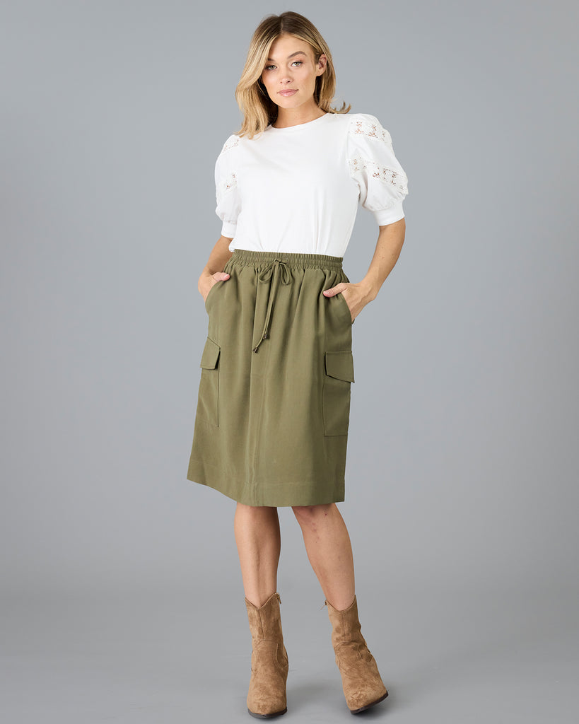 Woman in an olive green, knee length skirt