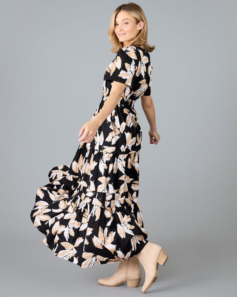 Woman in a black with white/tan floral print, short sleeve maxi dress