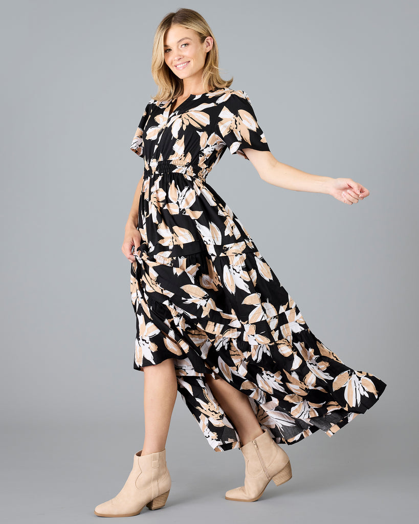 Woman in a black with white/tan floral print, short sleeve maxi dress