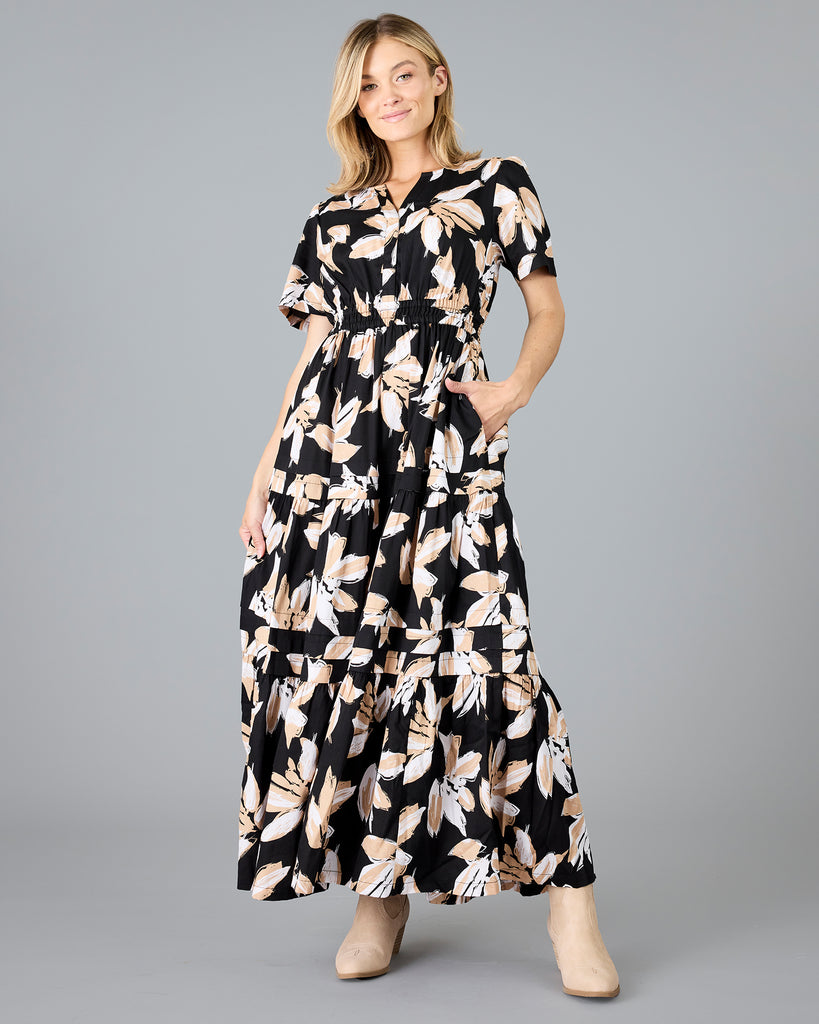 Woman in a black with white/tan floral print, short sleeve maxi dress