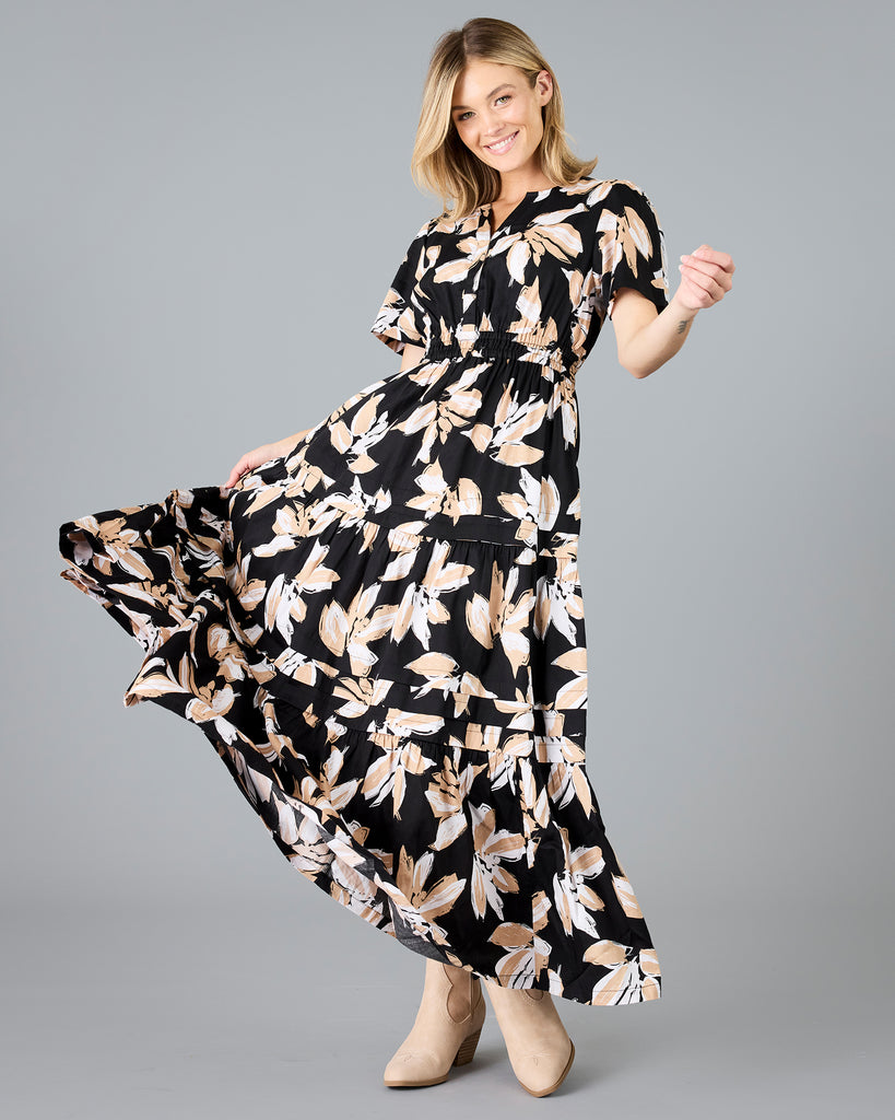 Woman in a black with white/tan floral print, short sleeve maxi dress