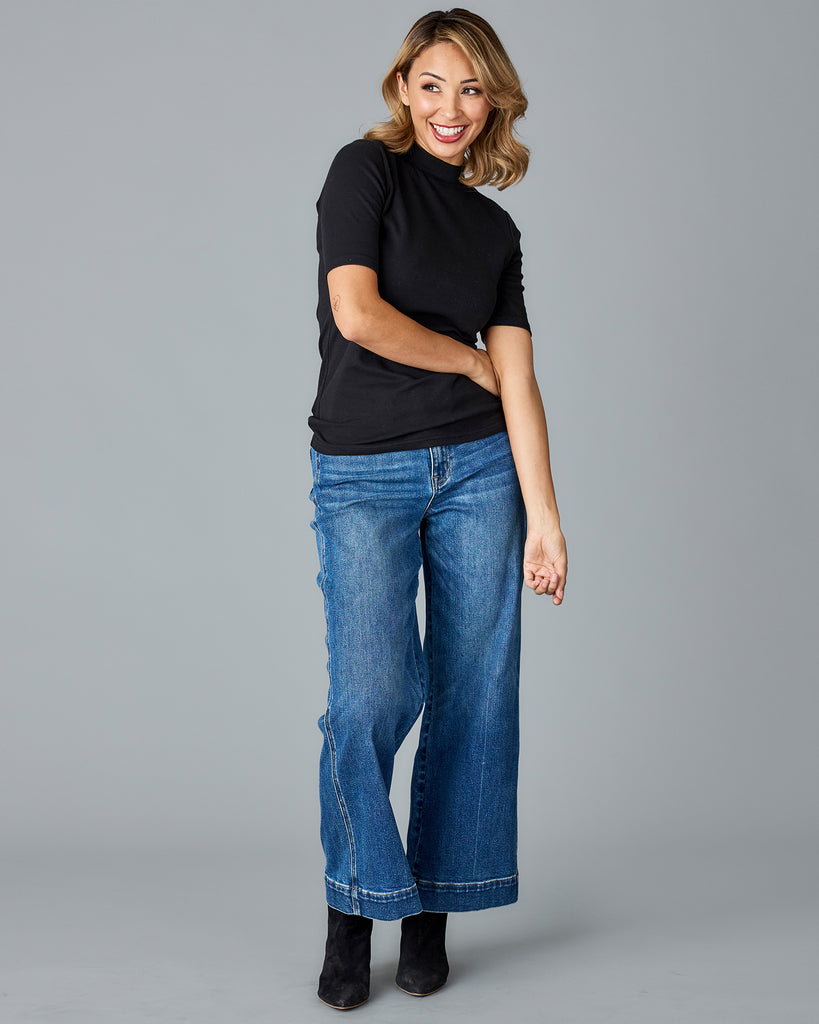 Woman in a black, half sleeved mock neck top