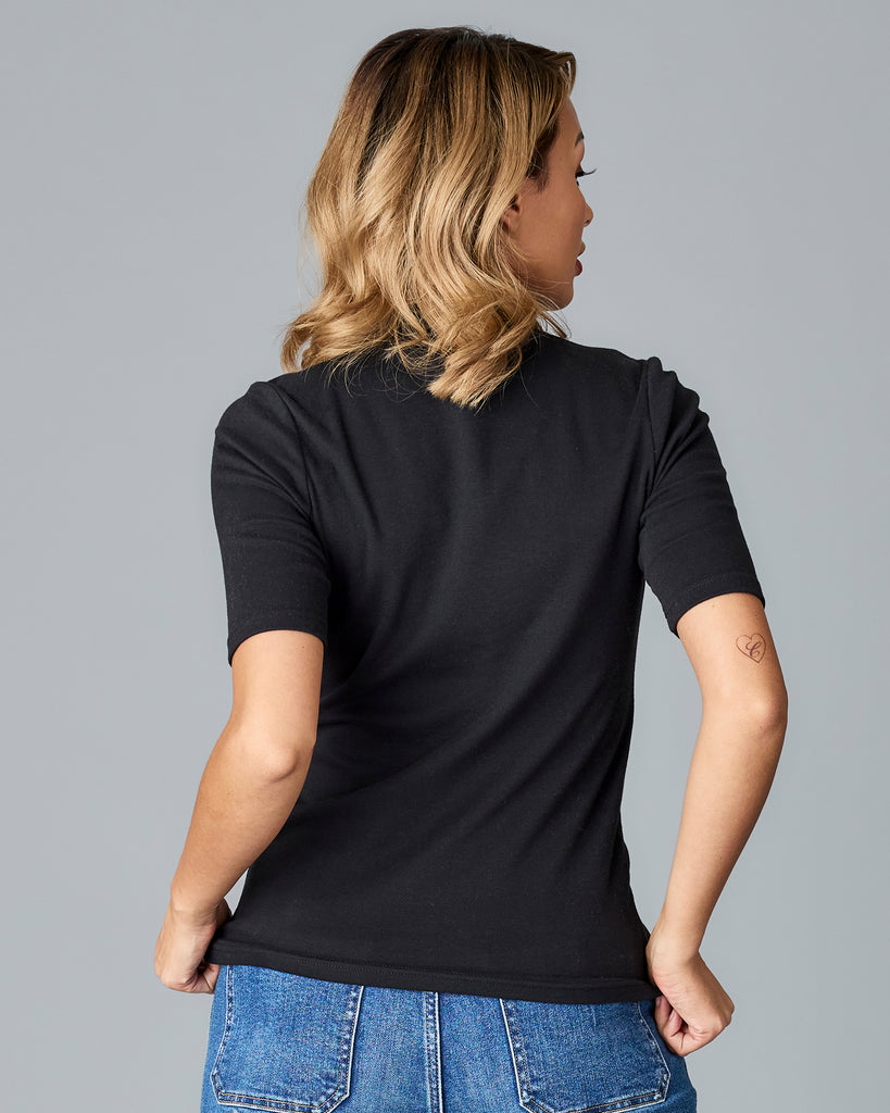 Woman in a black, half sleeved mock neck top