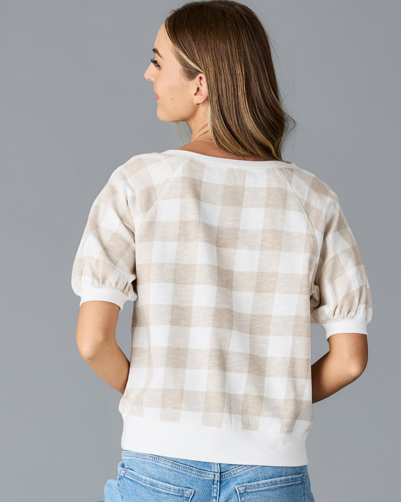 Woman in a tan and white plaid, short sleeve thing sweater