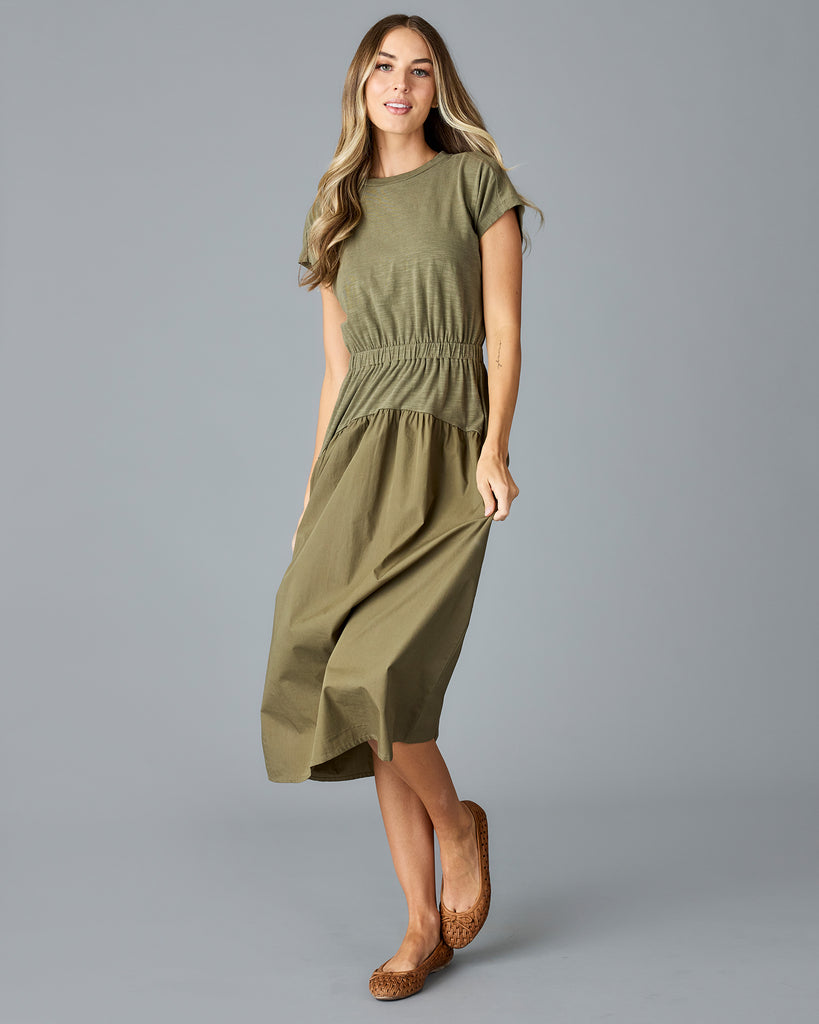 Woman in an olive green, short sleeve midi dress