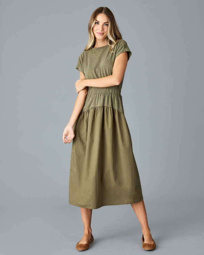 Woman in an olive green, short sleeve midi dress