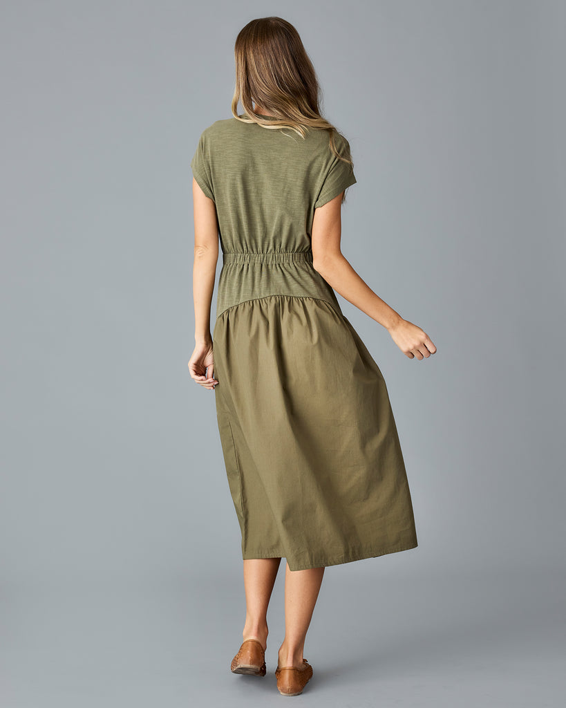 Woman in an olive green, short sleeve midi dress