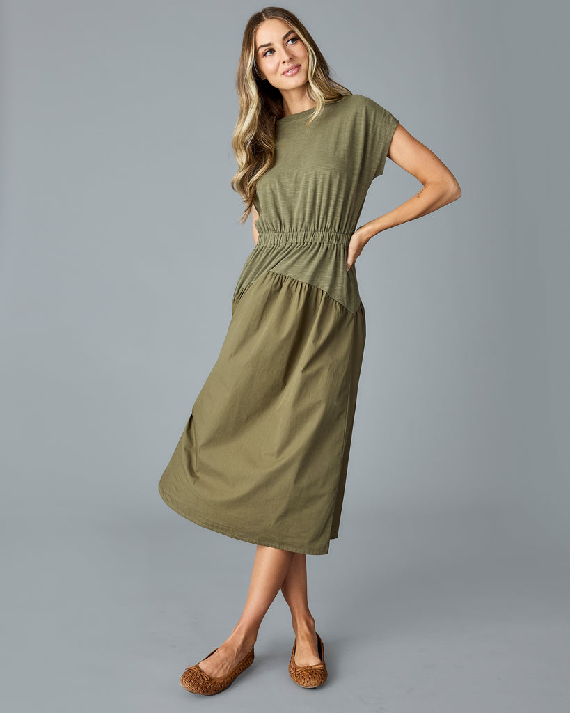 Woman in an olive green, short sleeve midi dress