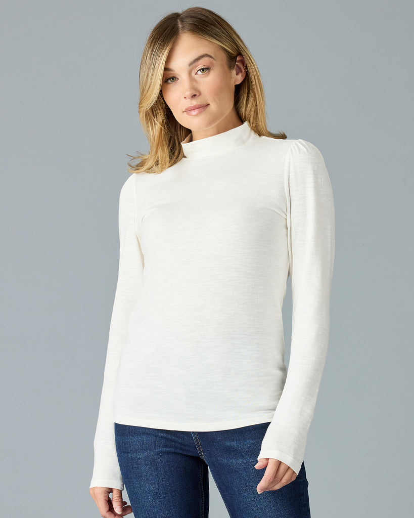 Woman in a white, long sleeve, mock neck basic tee