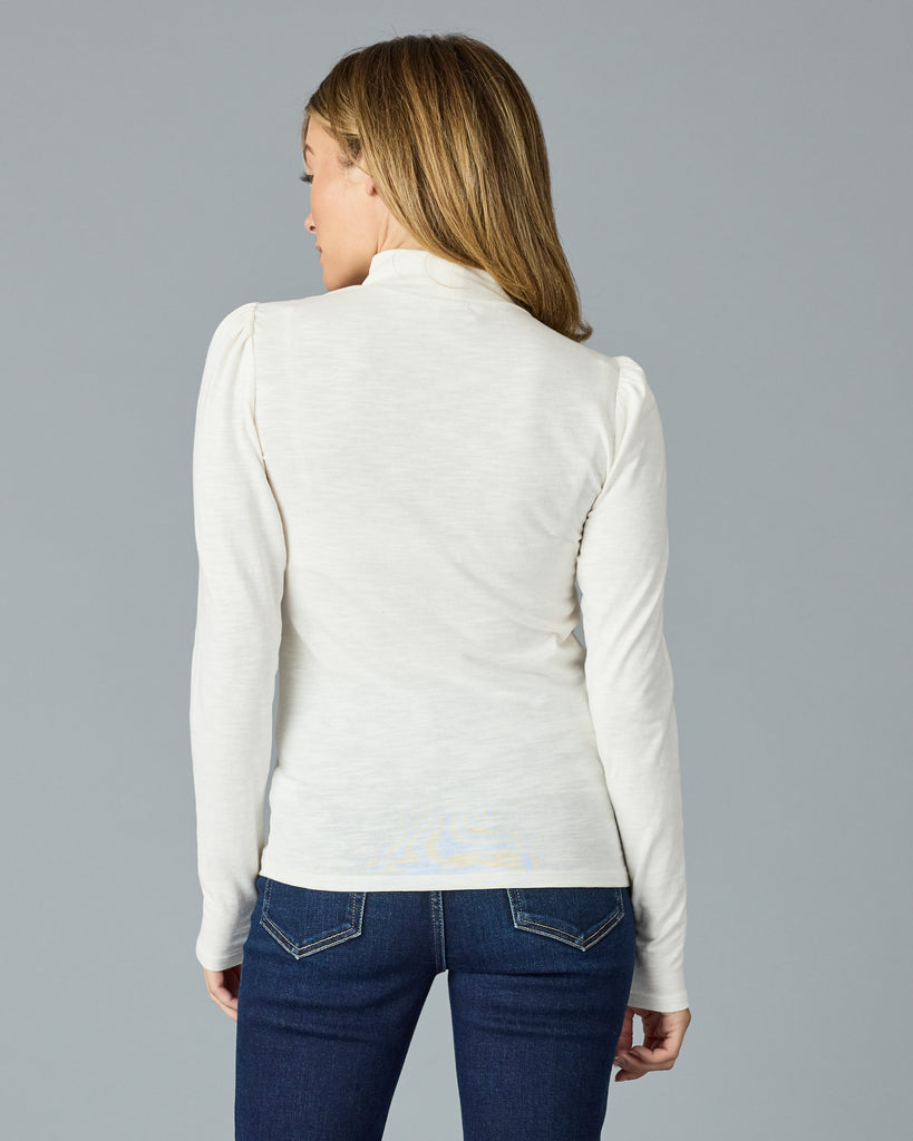 Woman in a white, long sleeve, mock neck basic tee