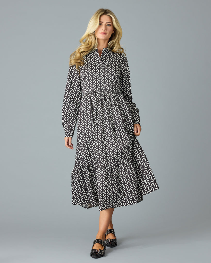 Woman in a black and white geometric print long sleeve midi dress