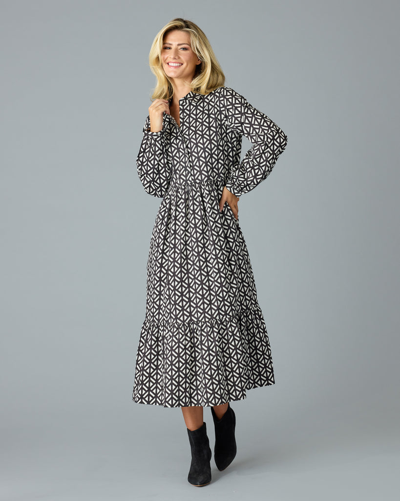 Woman in a black and white geometric print long sleeve midi dress