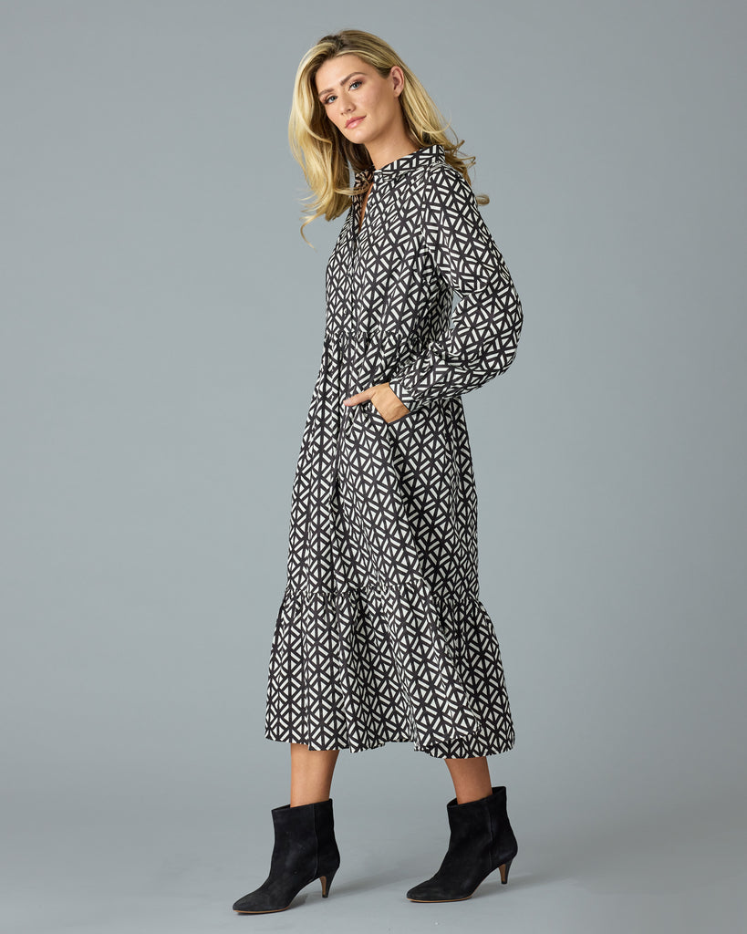 Woman in a black and white geometric print long sleeve midi dress