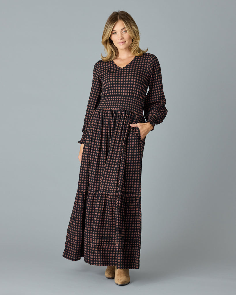 Woman in a black and brown plaid, long sleeve maxi dress