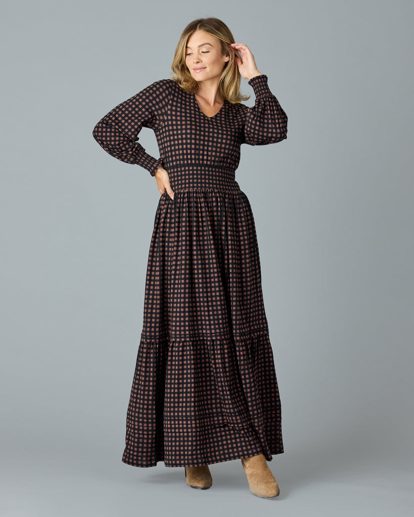 Woman in a black and brown plaid, long sleeve maxi dress