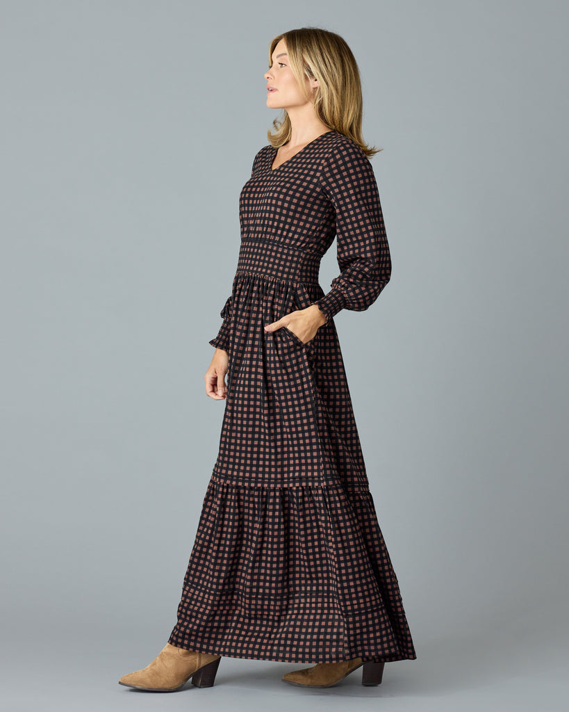 Woman in a black and brown plaid, long sleeve maxi dress