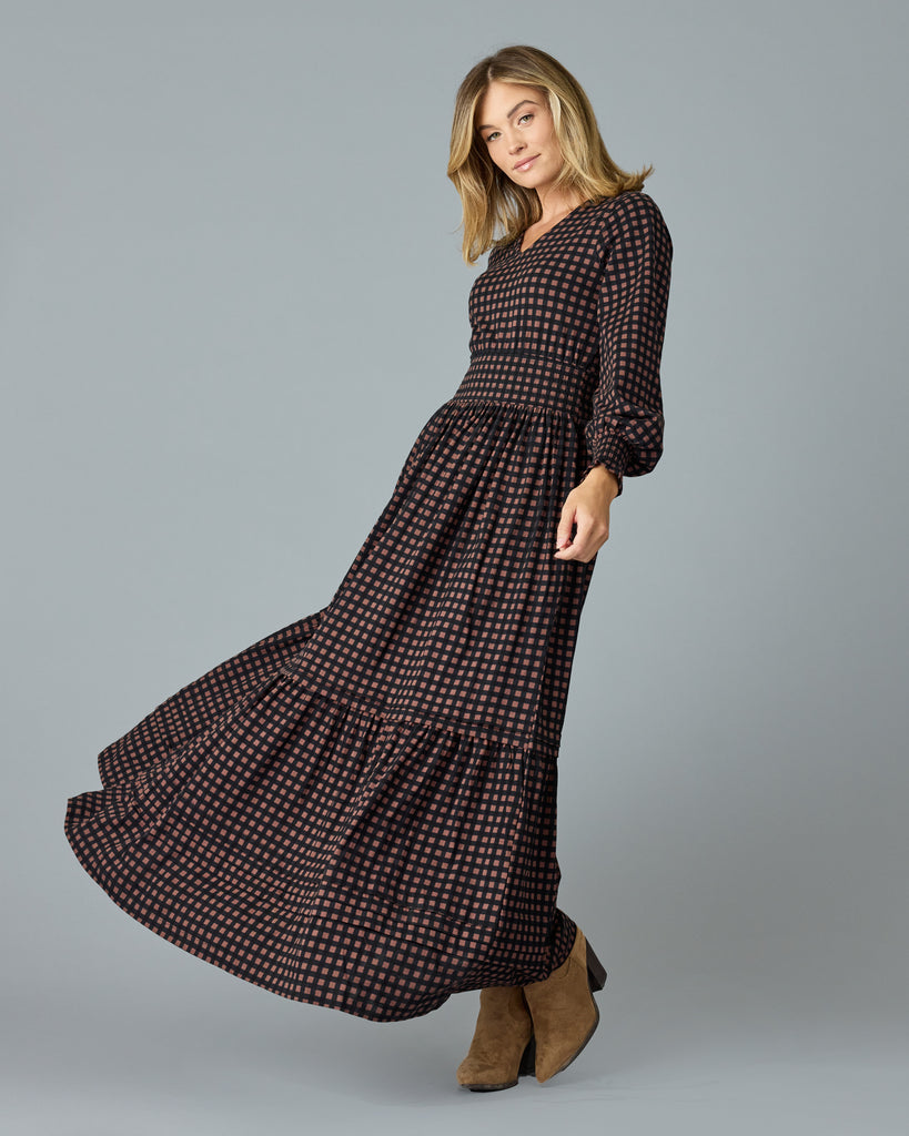 Woman in a black and brown plaid, long sleeve maxi dress