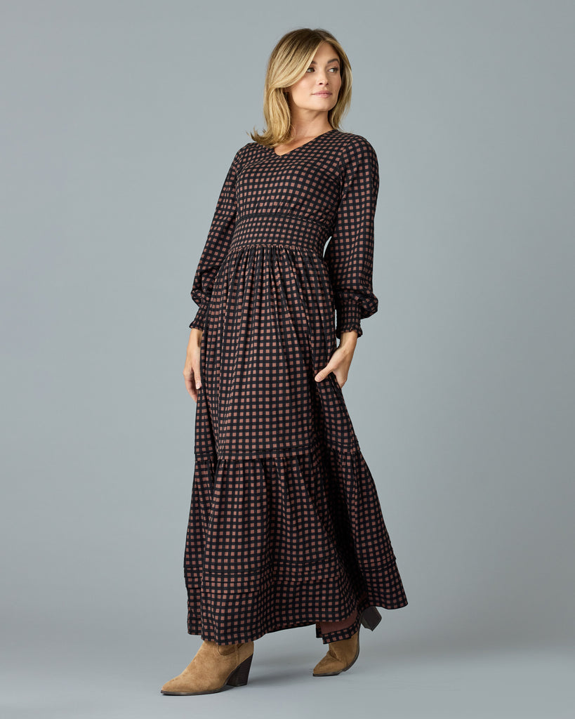 Woman in a black and brown plaid, long sleeve maxi dress