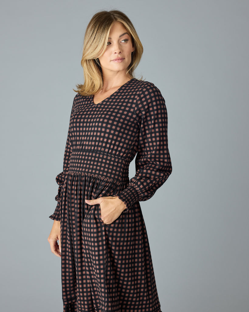 Woman in a black and brown plaid, long sleeve maxi dress