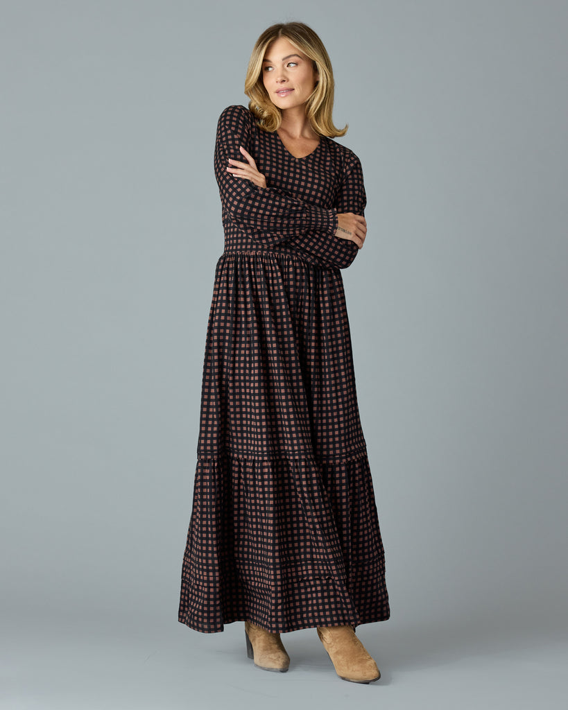 Woman in a black and brown plaid, long sleeve maxi dress