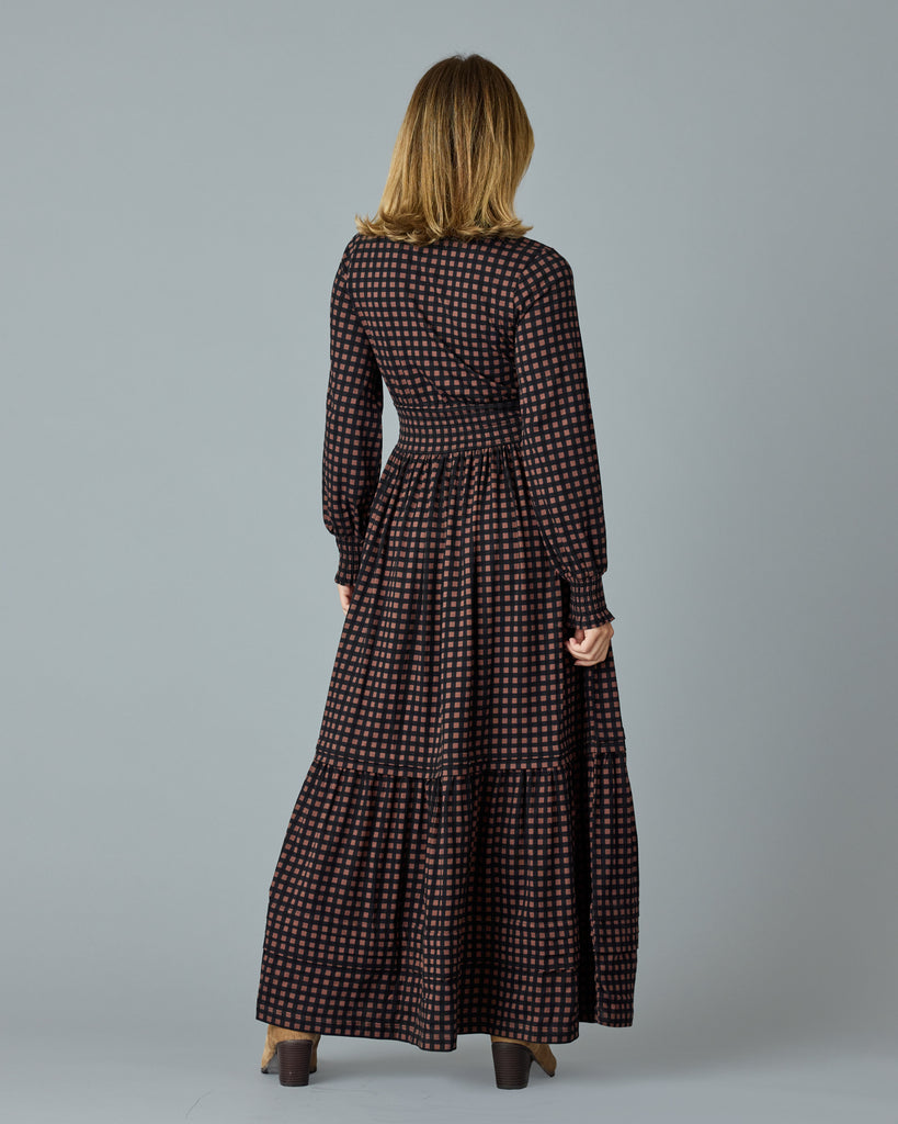 Woman in a black and brown plaid, long sleeve maxi dress