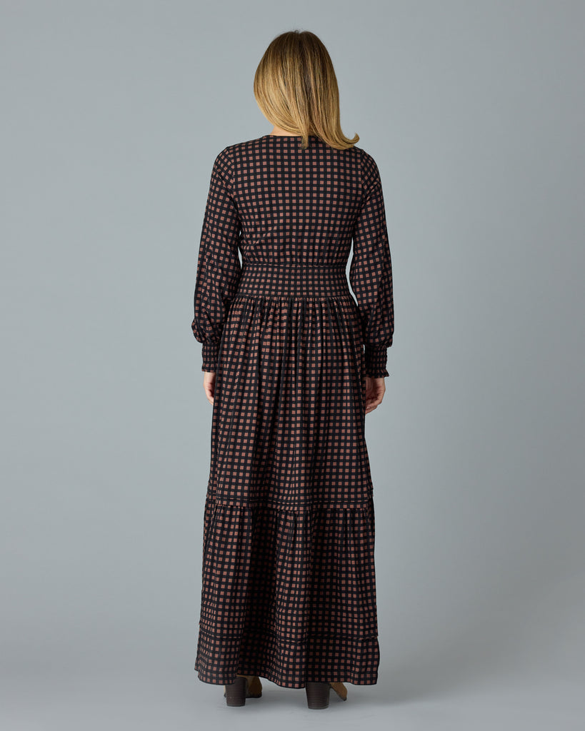 Woman in a black and brown plaid, long sleeve maxi dress