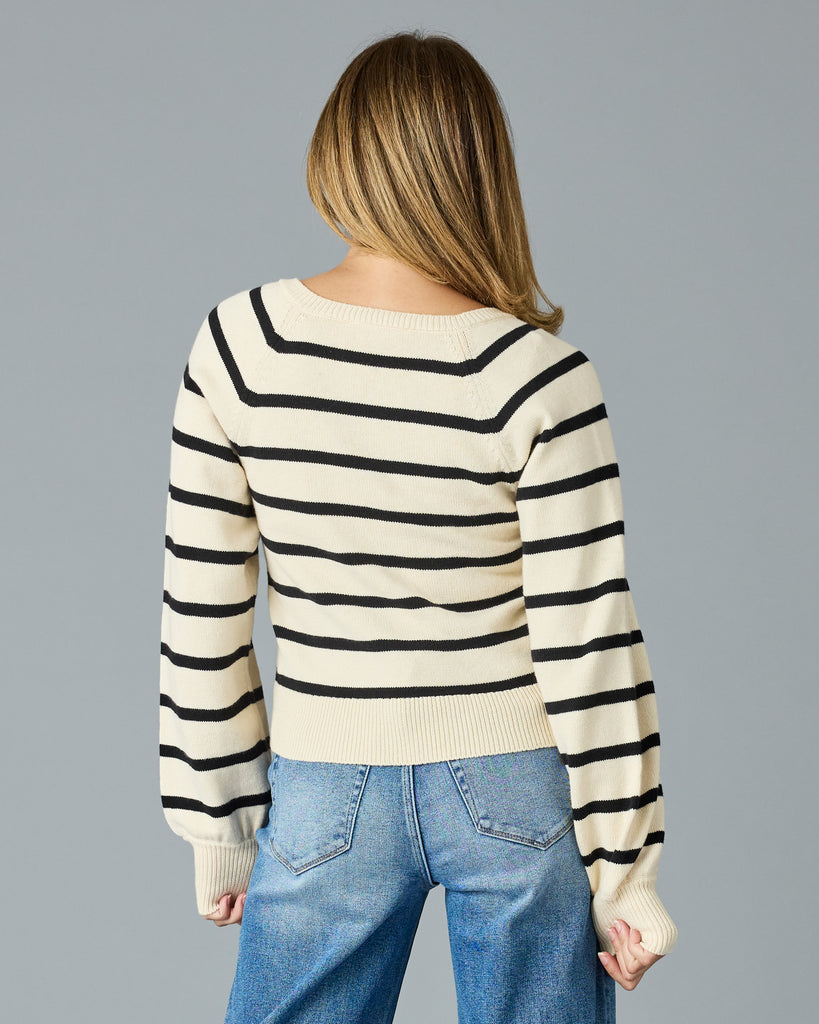 Woman in a black and tan striped sweater with buttons down the front