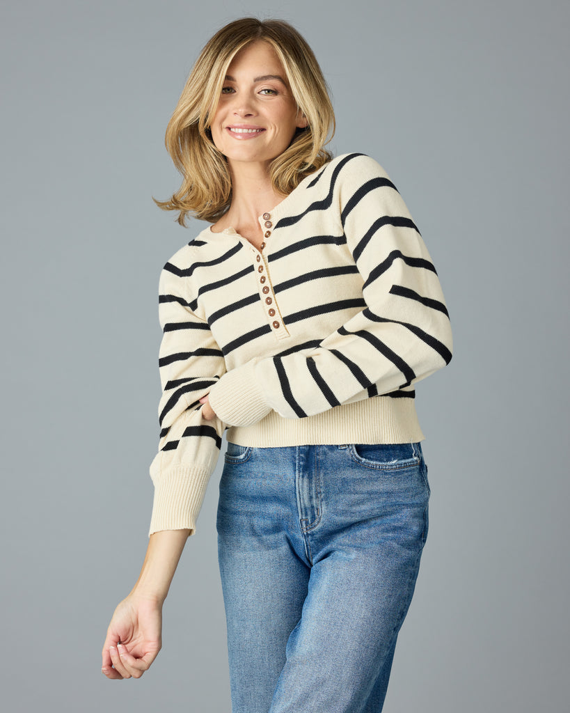 Woman in a black and tan striped sweater with buttons down the front