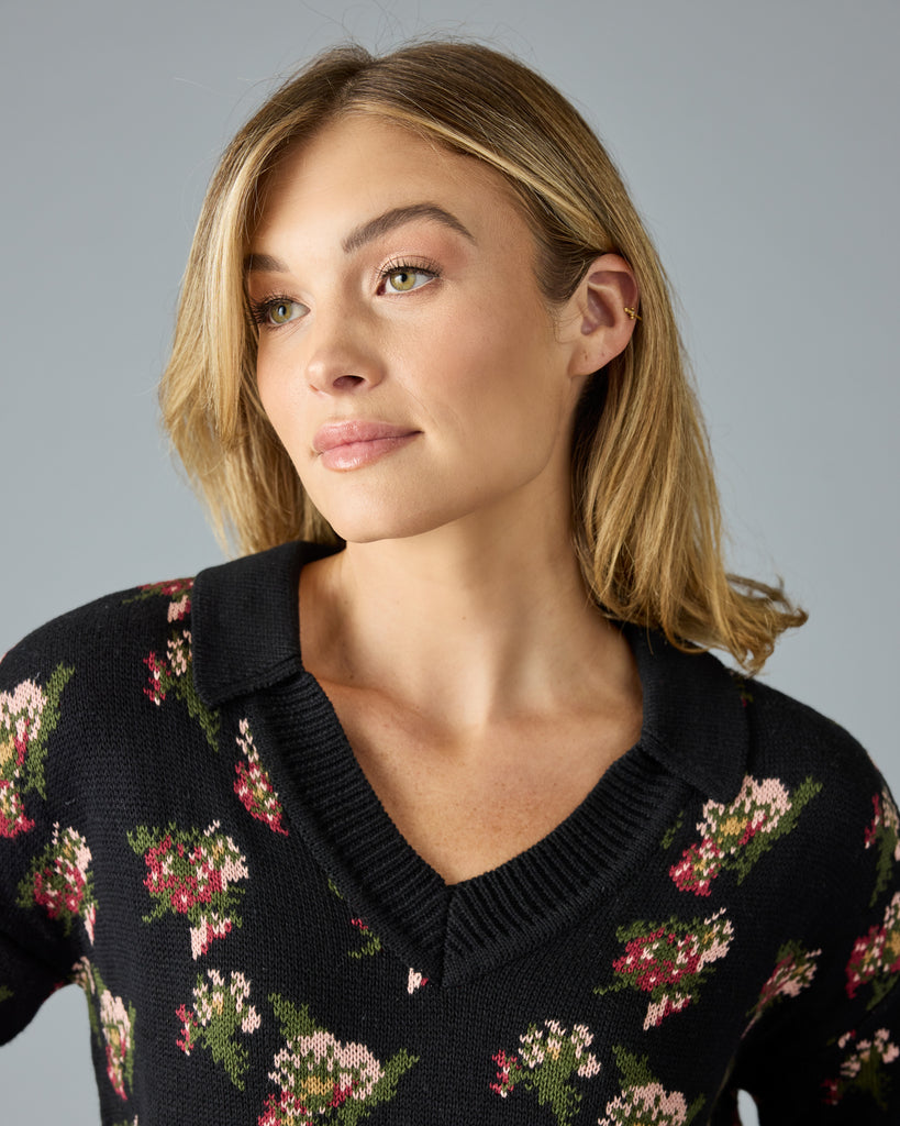 Woman in a black with floral print, long sleeve, v-neck sweater