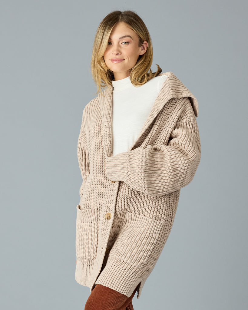 Woman in a tan, oversized cardigan