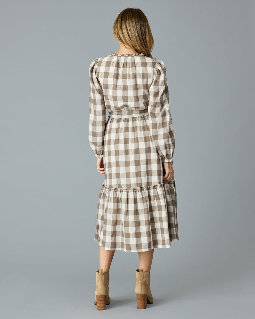 Woman in a brown plaid, long sleeve, v-neck, midi dress