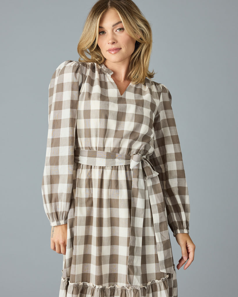 Woman in a brown plaid, long sleeve, v-neck, midi dress