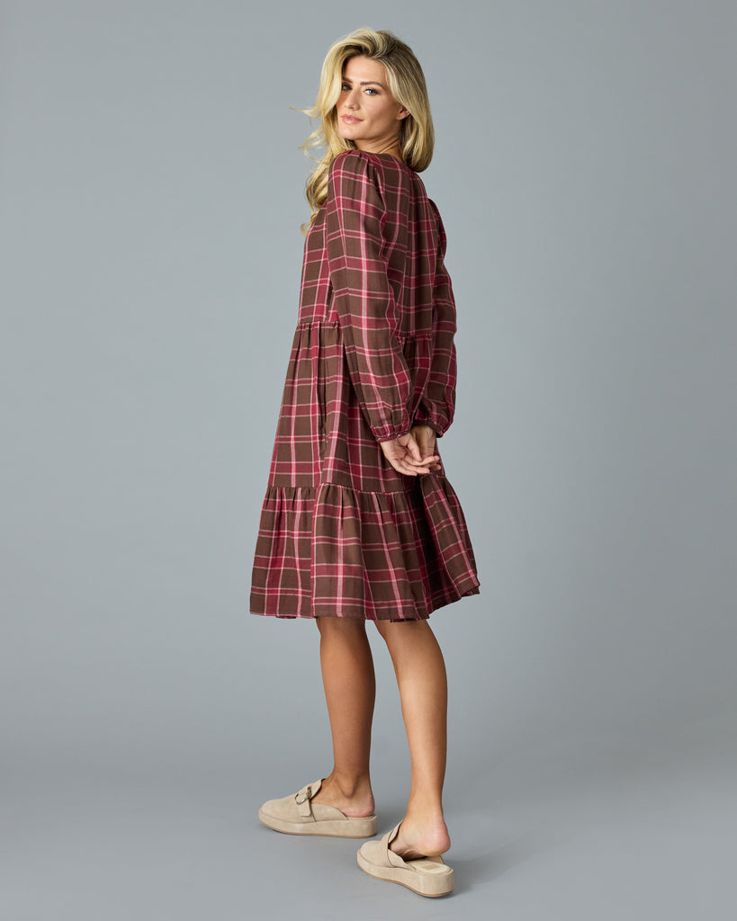 Woman in a maroon plaid, long sleeve, midi dress