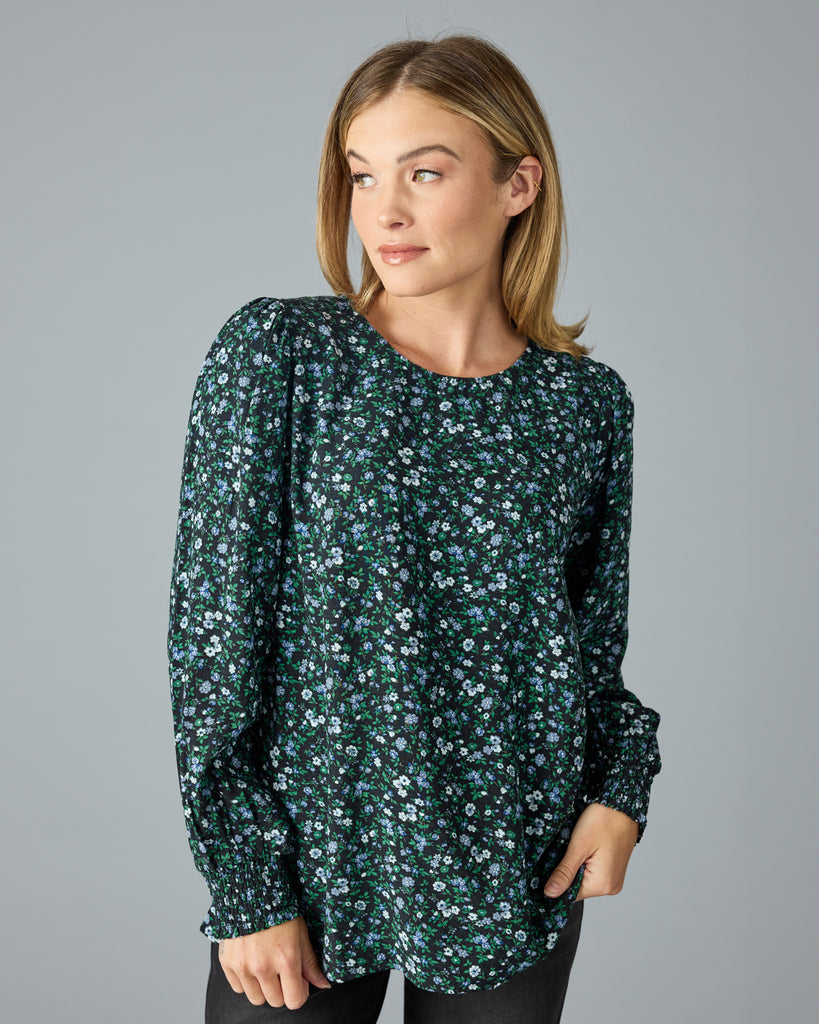 Woman in a green and blue floral print long sleeve blouse