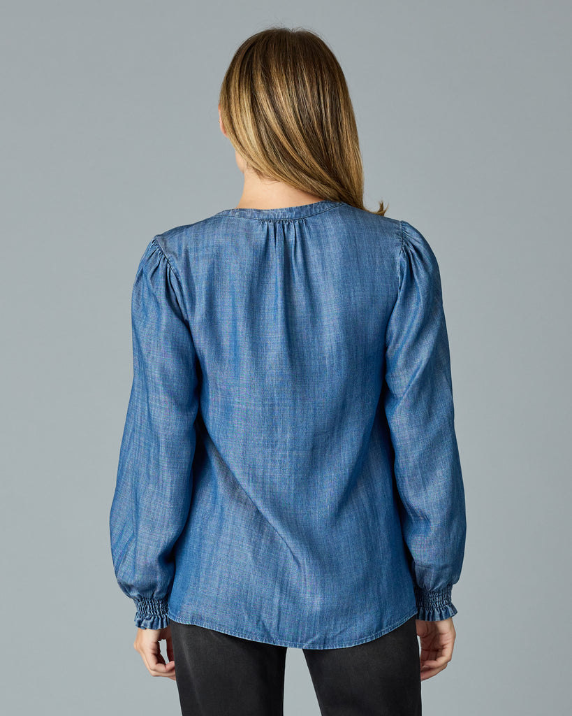 Woman in a long sleeve, dark chambray top