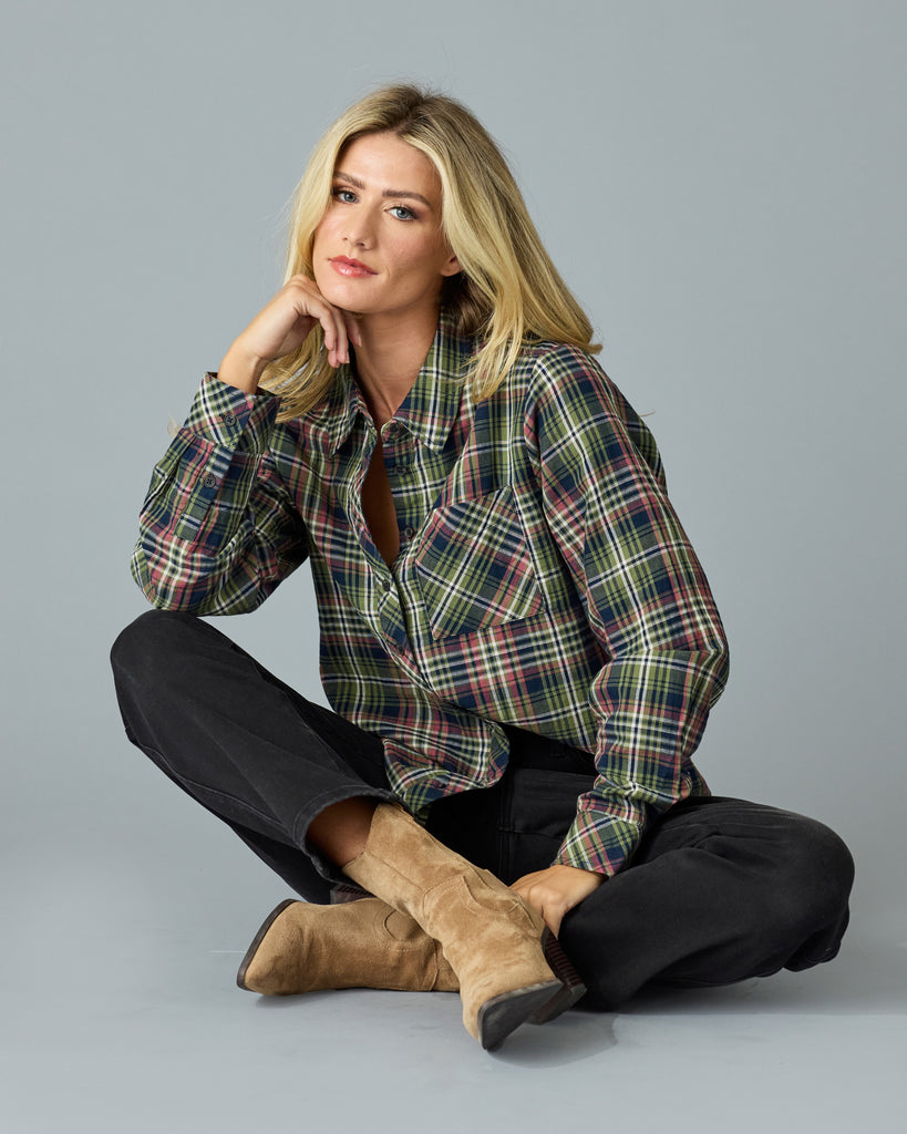 Woman in a green and pink plaid long sleeve buttondown top