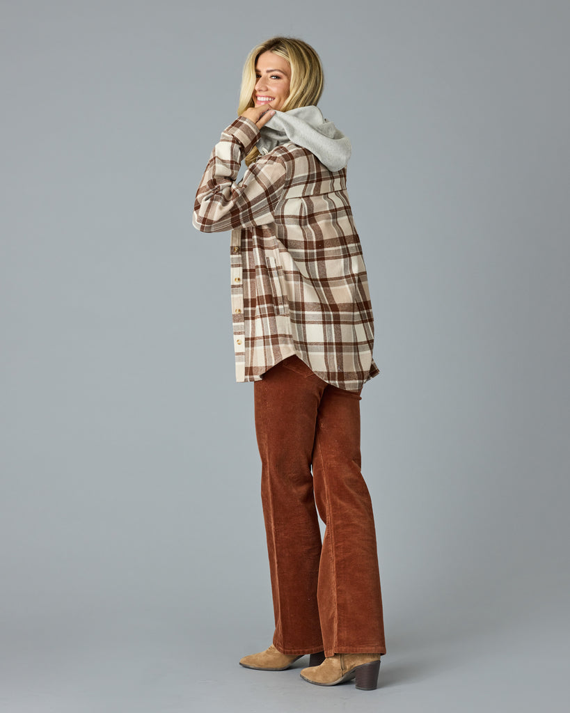 Woman in a tan plaid buttondown with a sweater hood attached