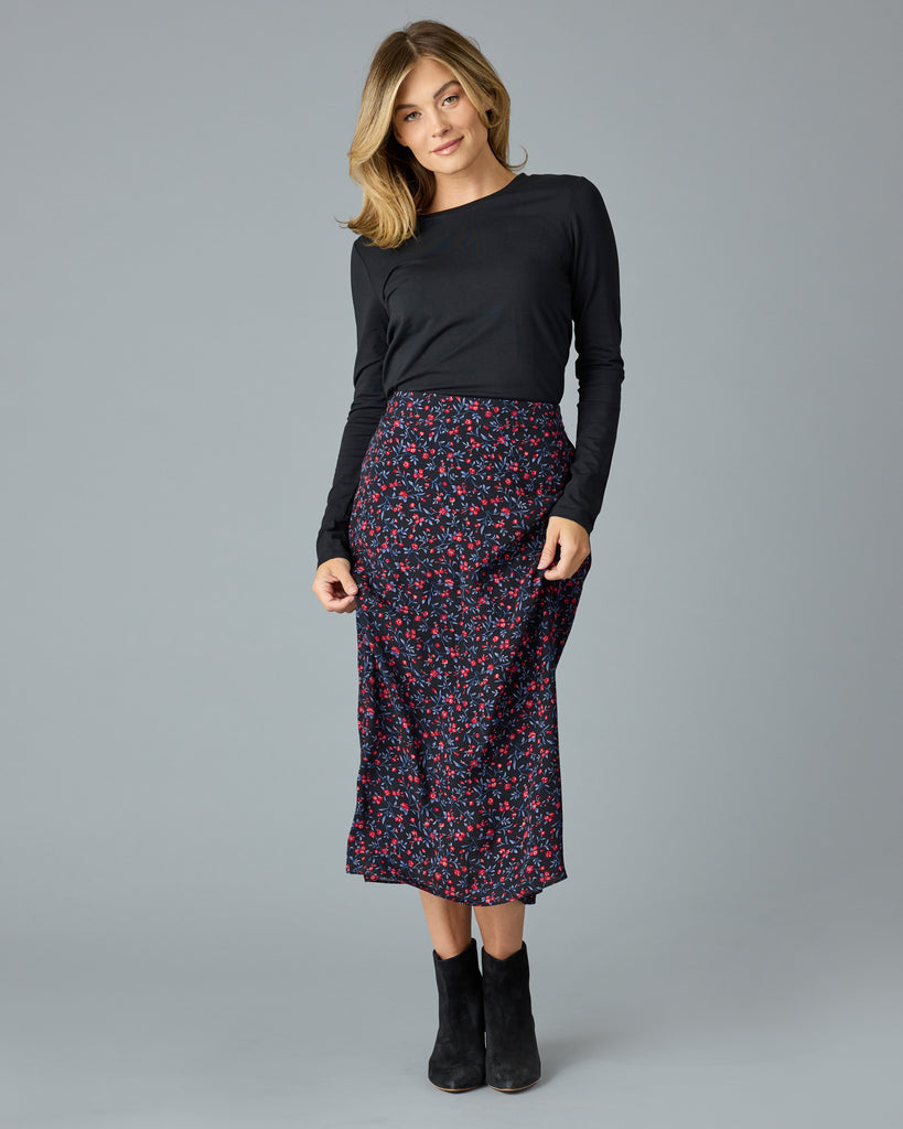 Woman in a black with floral print midi length skirt