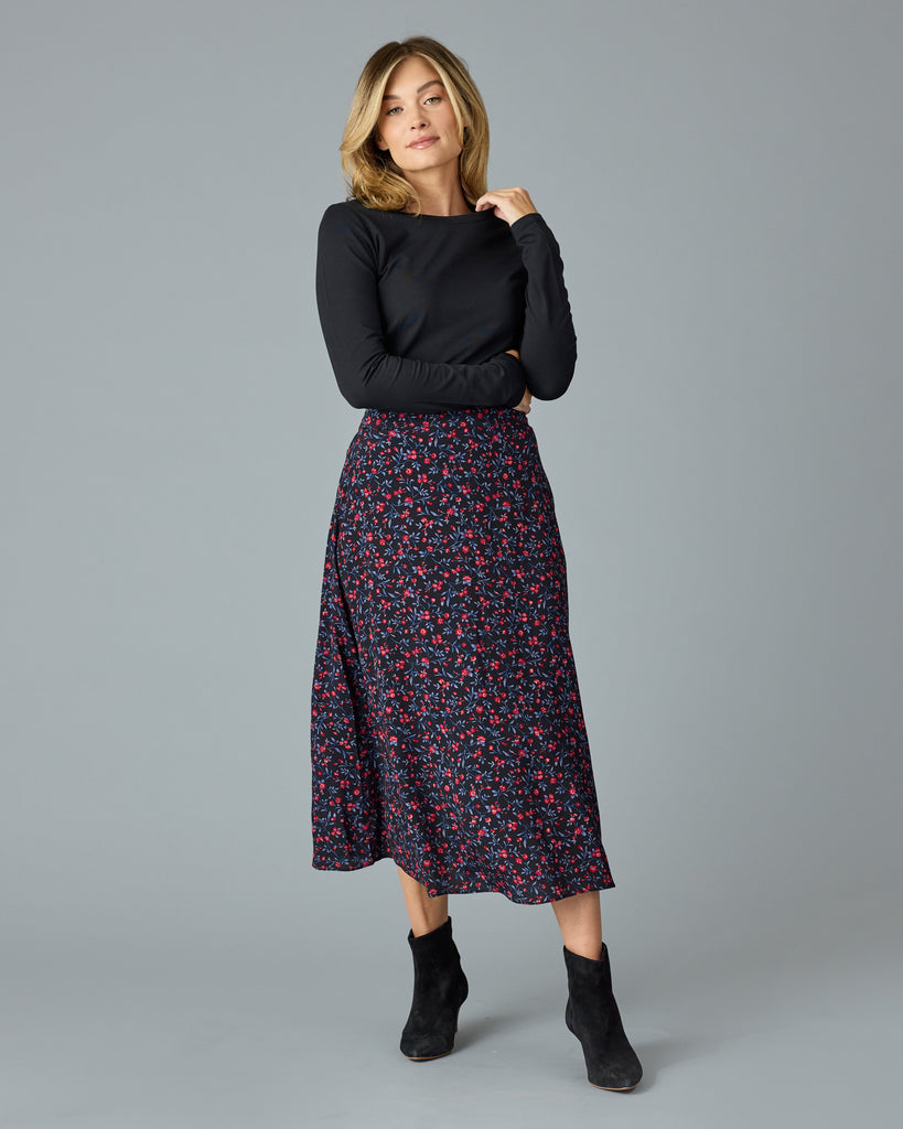 Woman in a black with floral print midi length skirt