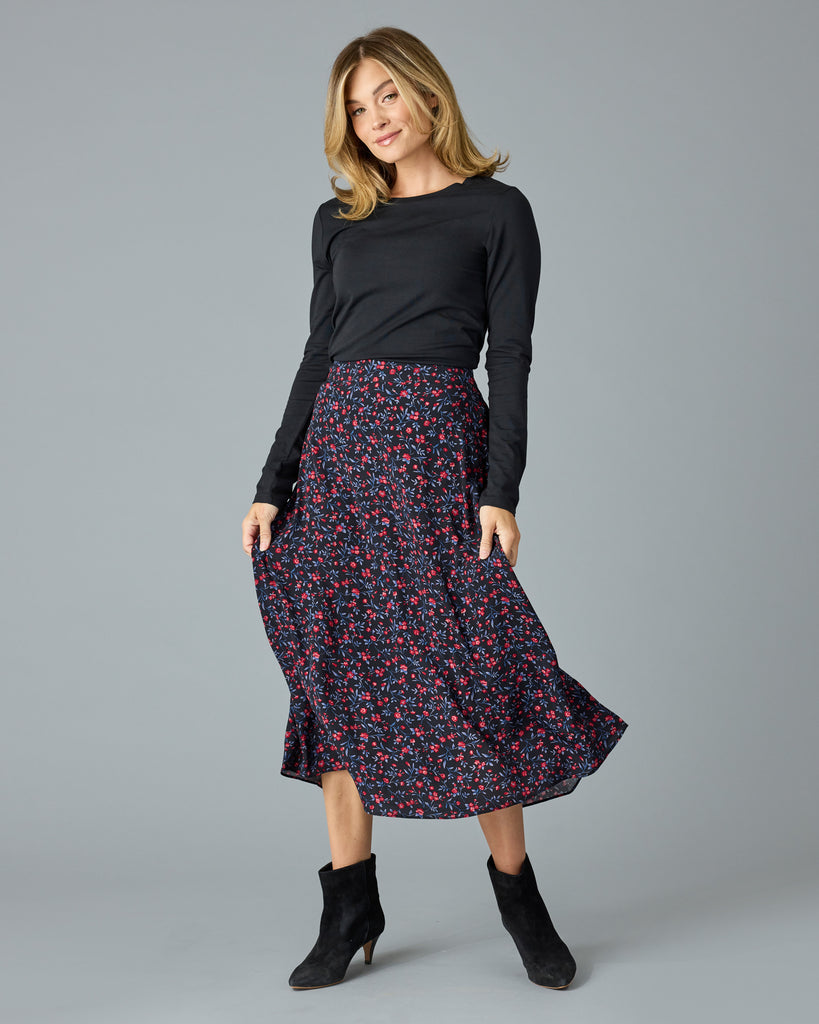 Woman in a black with floral print midi length skirt