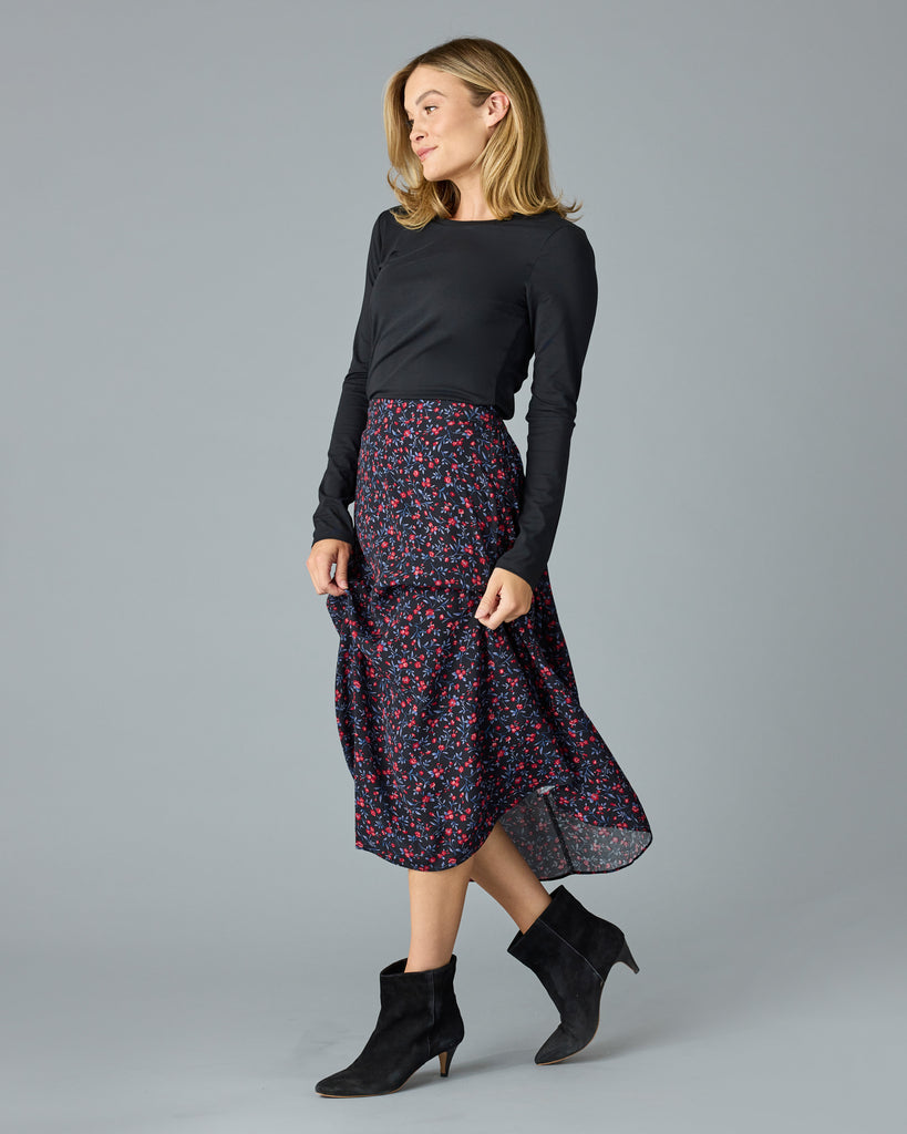 Woman in a black with floral print midi length skirt