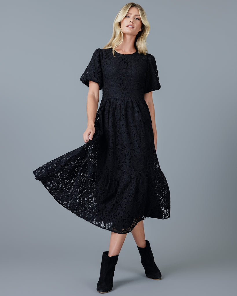 Woman in a black short sleeve midi-length lace dress