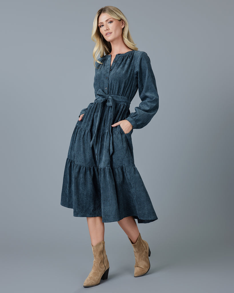 Woman in a blue velvet-y corduroy long sleeve midi dress